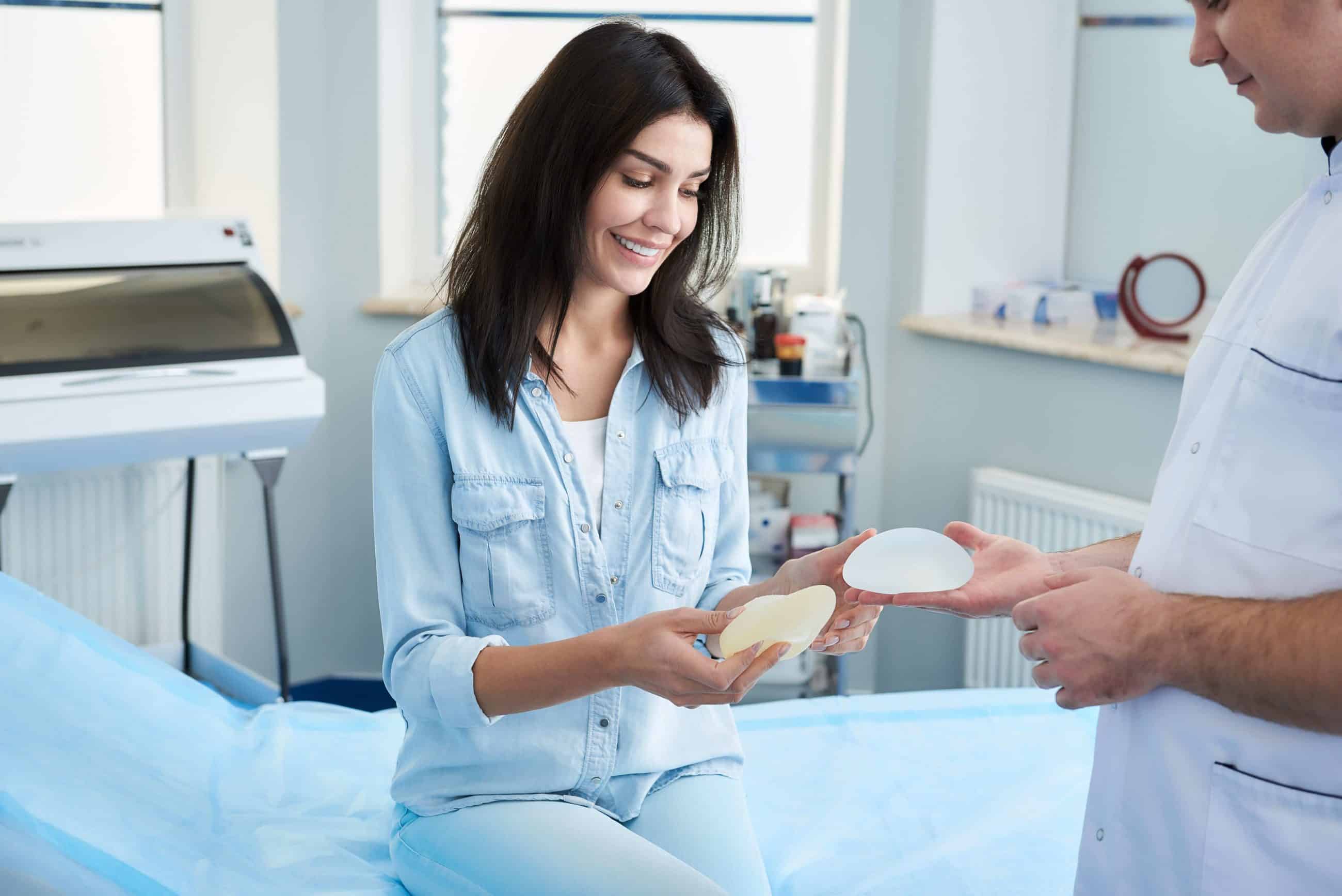 woman and Sydney plastic surgeon holding breast implants