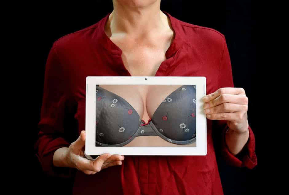 woman holding a photo of breasts in a bra